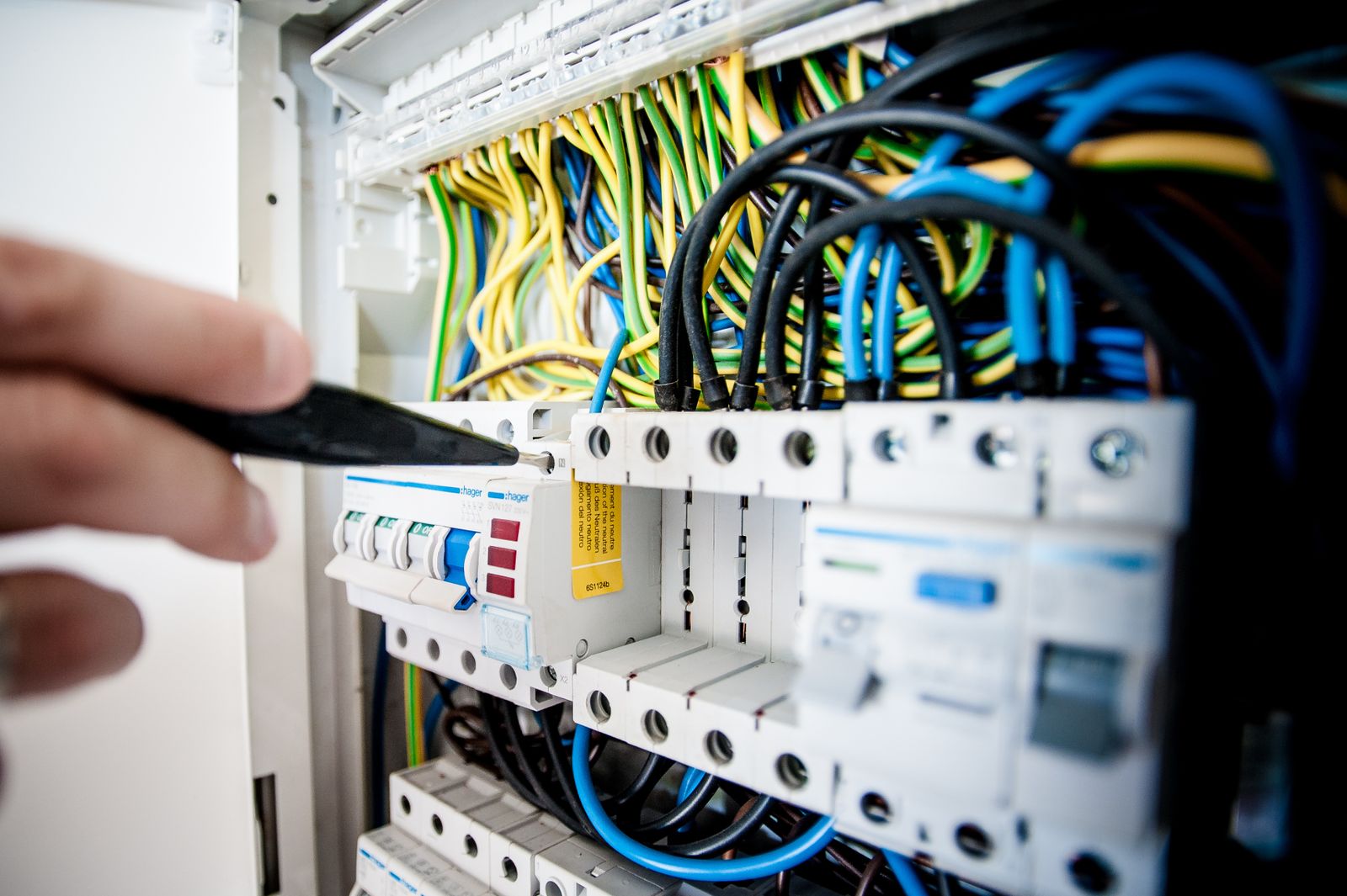 Elektriker der arbejder i en eltavle